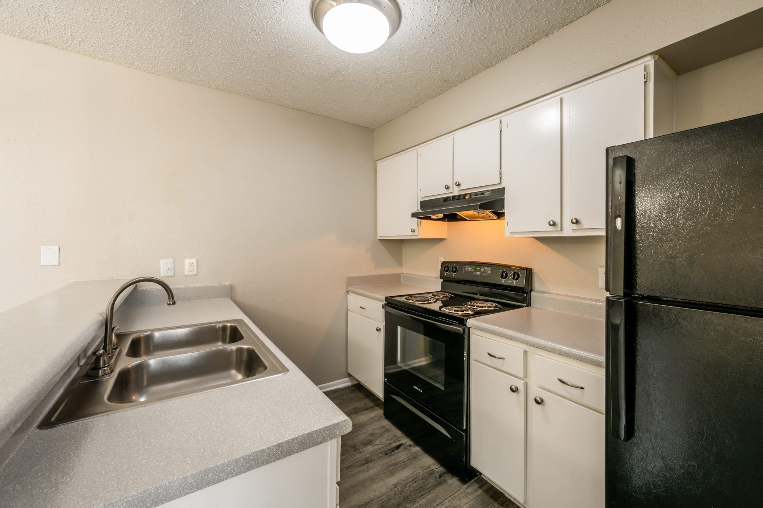 Pet-Friendly Apartments in San Antonio, TX - City-Base Vista - Kitchen Area with Black Appliances, Spacious Counterspace, and White Cabinets