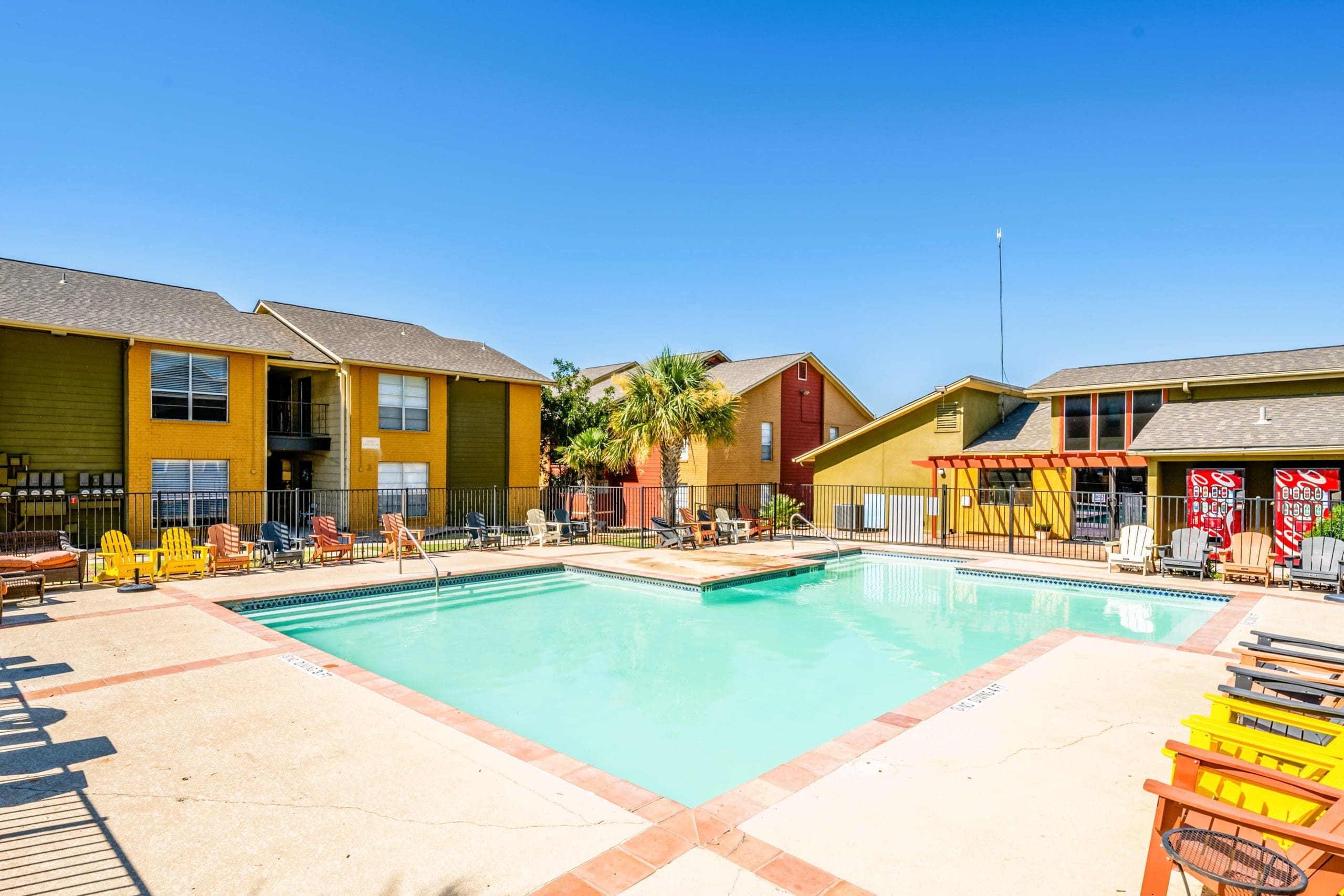 Dog-Friendly Apartments in San Antonio, TX - City-Base Vista - Pool with Lounge Chairs and View of Apartment Buildings
