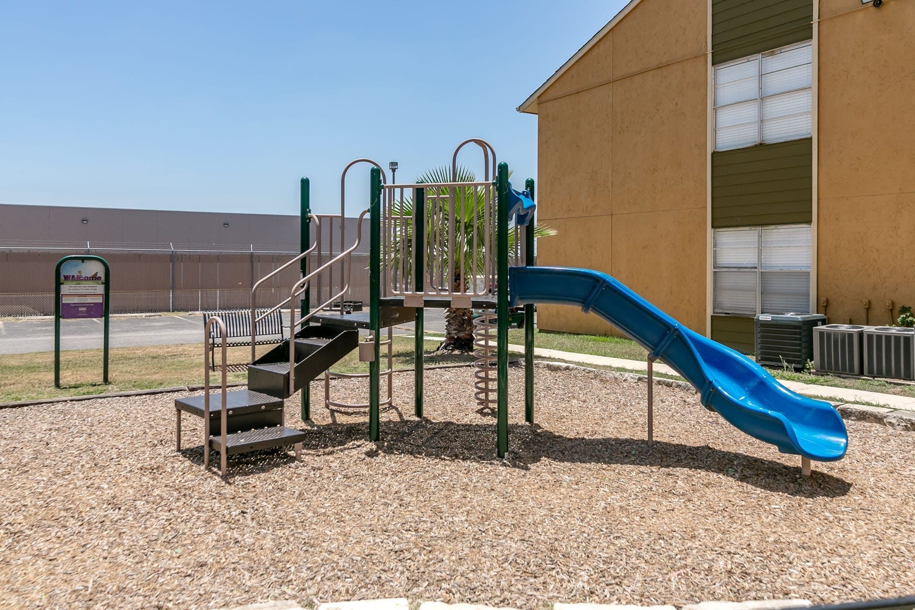 Apartments in San Antonio, TX for Rent - City-Base Vista - Playground with Slide, Bench Seating, and Woodchips